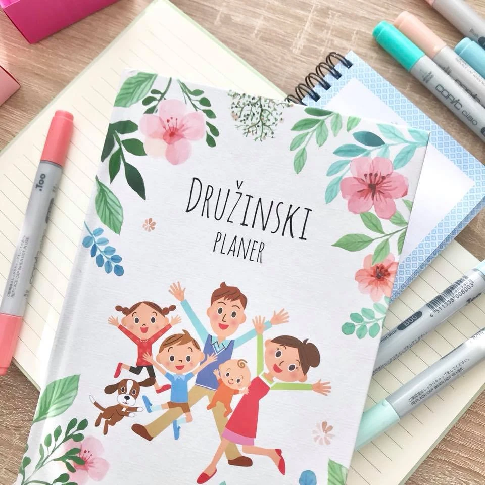 The illustrated cover of the Planko family planner, photographed with stationery.