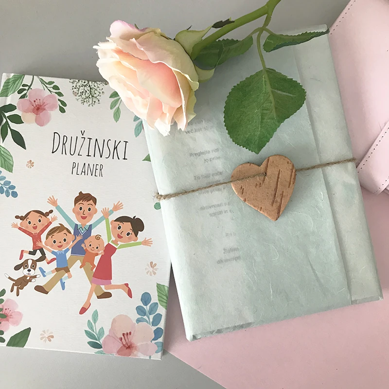 A Planko family planner wrapped as a gift with a rose.